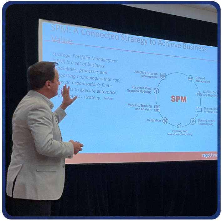 Presenter gestures toward slide on SPM strategy during a conference session.