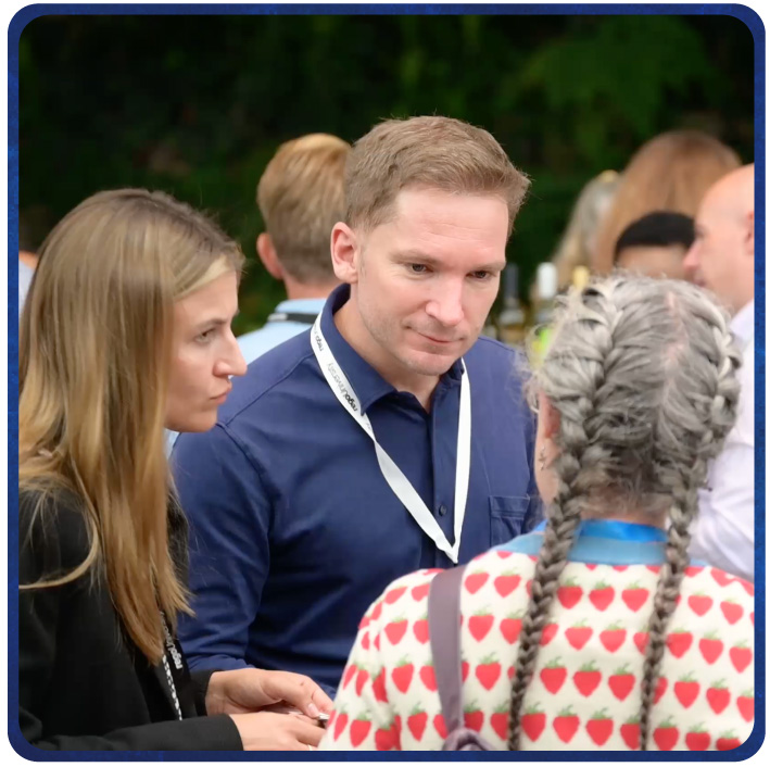 Three attendees talking during a networking event, connecting during a professional summit. 