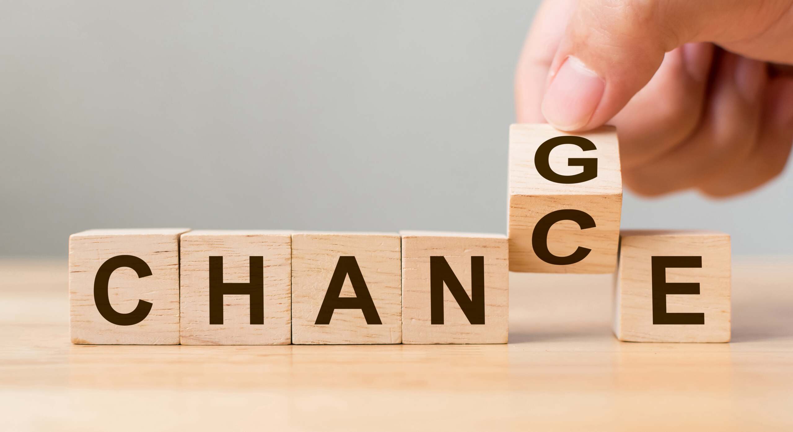 CHANGE blocks Above wooden blocks, hand replaces the second C in “chance” with a G to form “change”