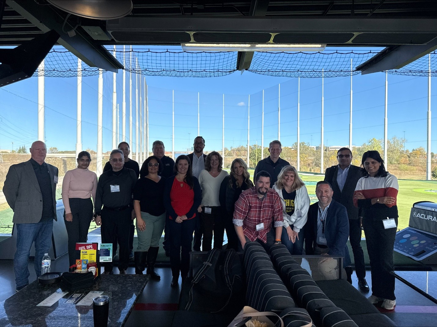 Michigan top golf Group photo of Clarity user group attendees at a Topgolf venue during a networking event.