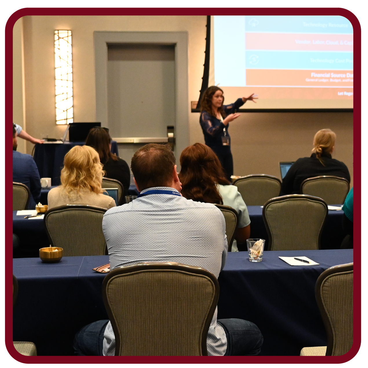Presenter leads a Rego University session while attendees learn practical strategies for technology and portfolio management.